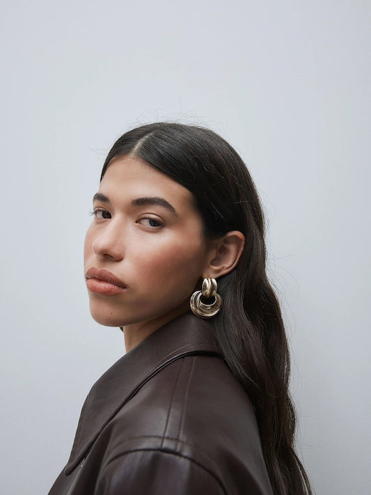 Gold-colored statement hoop earrings with pendants